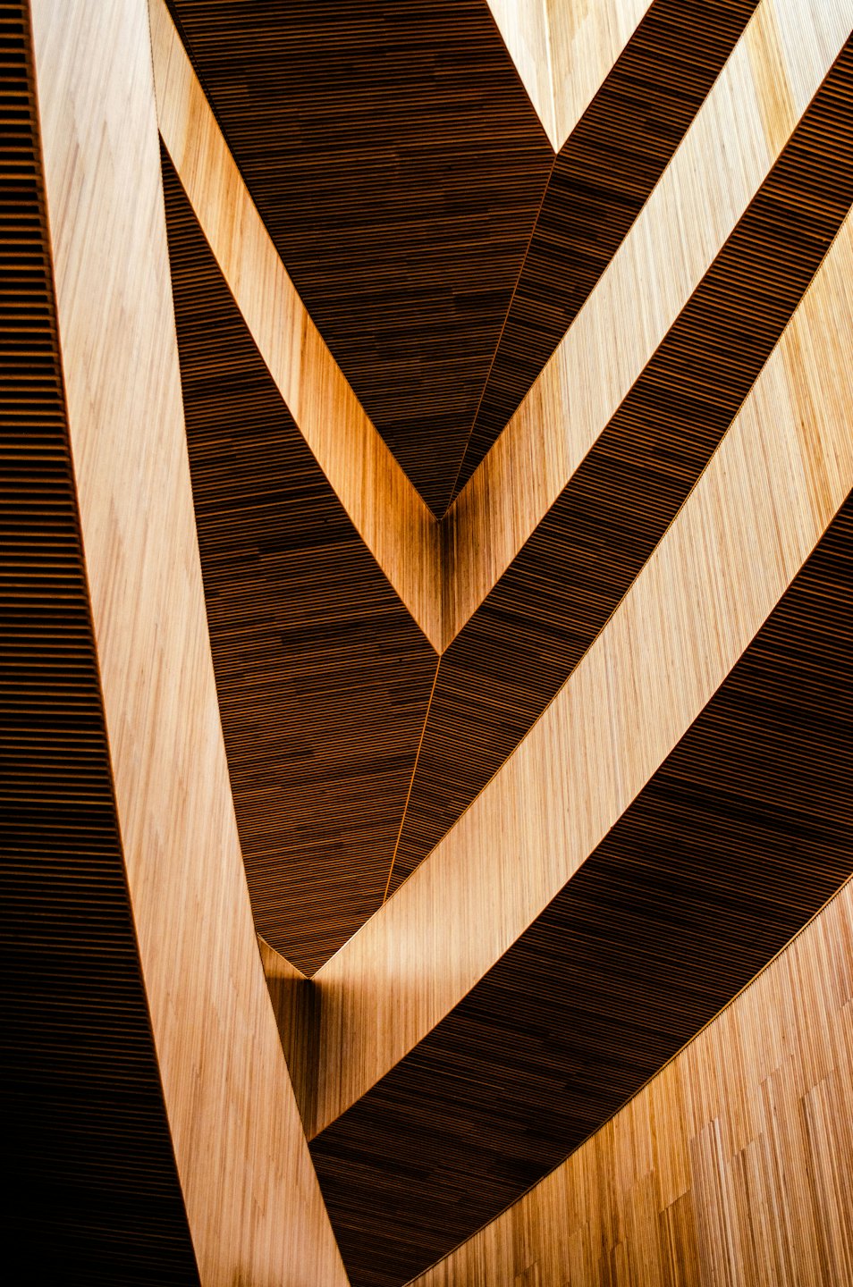Moderne Holzverkleidung mit dunkelbraunen Lamellen und hellbraunen Paneelen.